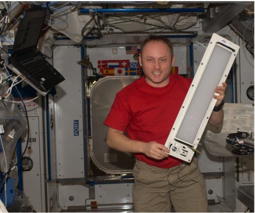 Photo courtesy of NASA Electric light is coming to the astronauts’ aid in the form of a programmable LED wavelength system. U.S. Astronaut Mike Fincke holds an early prototype of an LED lighting unit that was installed on the space station during Expedition 18 about six years ago.