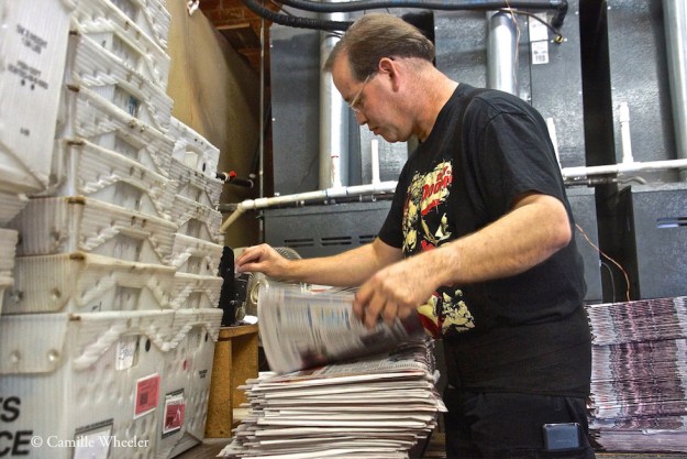 Production Manager Shannon Whorton whips through stacks of soon-to-be-mailed newspapers with the aid of an electric label dispenser.