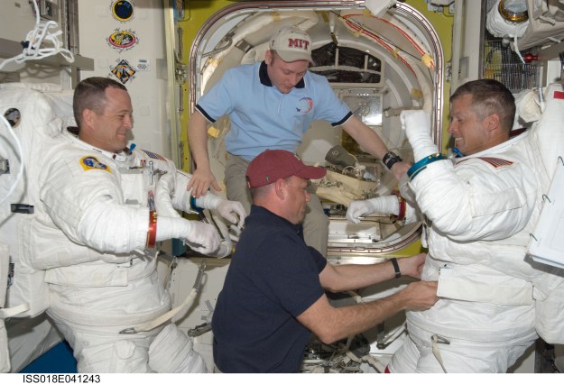 Photo credit: NASA After a March 19, 2009, spacewalk outside the International Space Station, astronauts Ricky Arnold, left, and Steve Swanson shed their Extravehicular Mobility Unit spacesuits with help from Expedition 18 commander Michael Fincke, top center, and Tony Antonelli, STS-119 pilot for the 28th space shuttle mission to the space station.